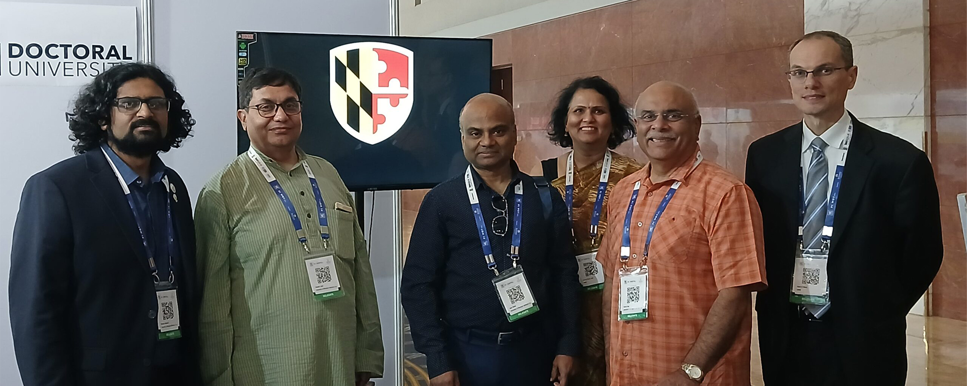 Group of six people at conference booth.