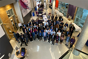 Photograph from above shows large number of IEEE Baltimore Technical Colloquium attendees gathering in a corridor for a group picture.